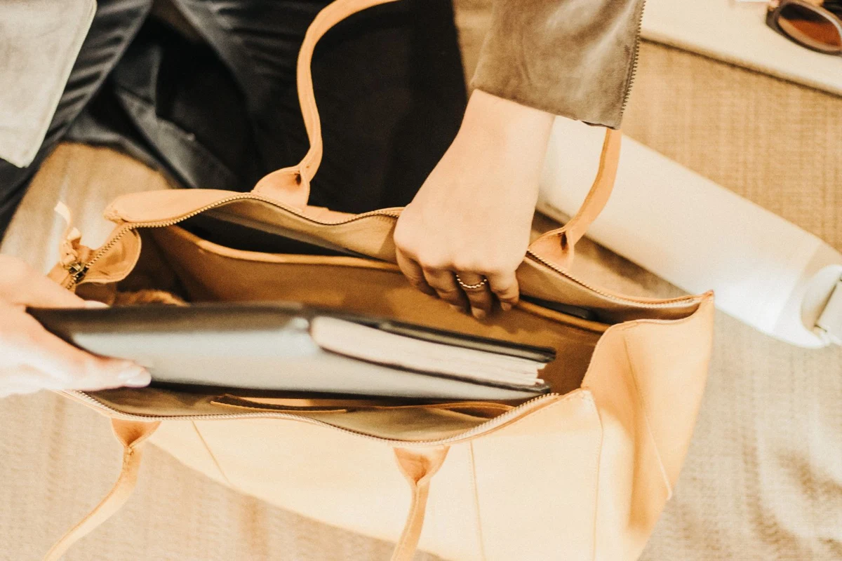 A tote bag holding a laptop and notebook