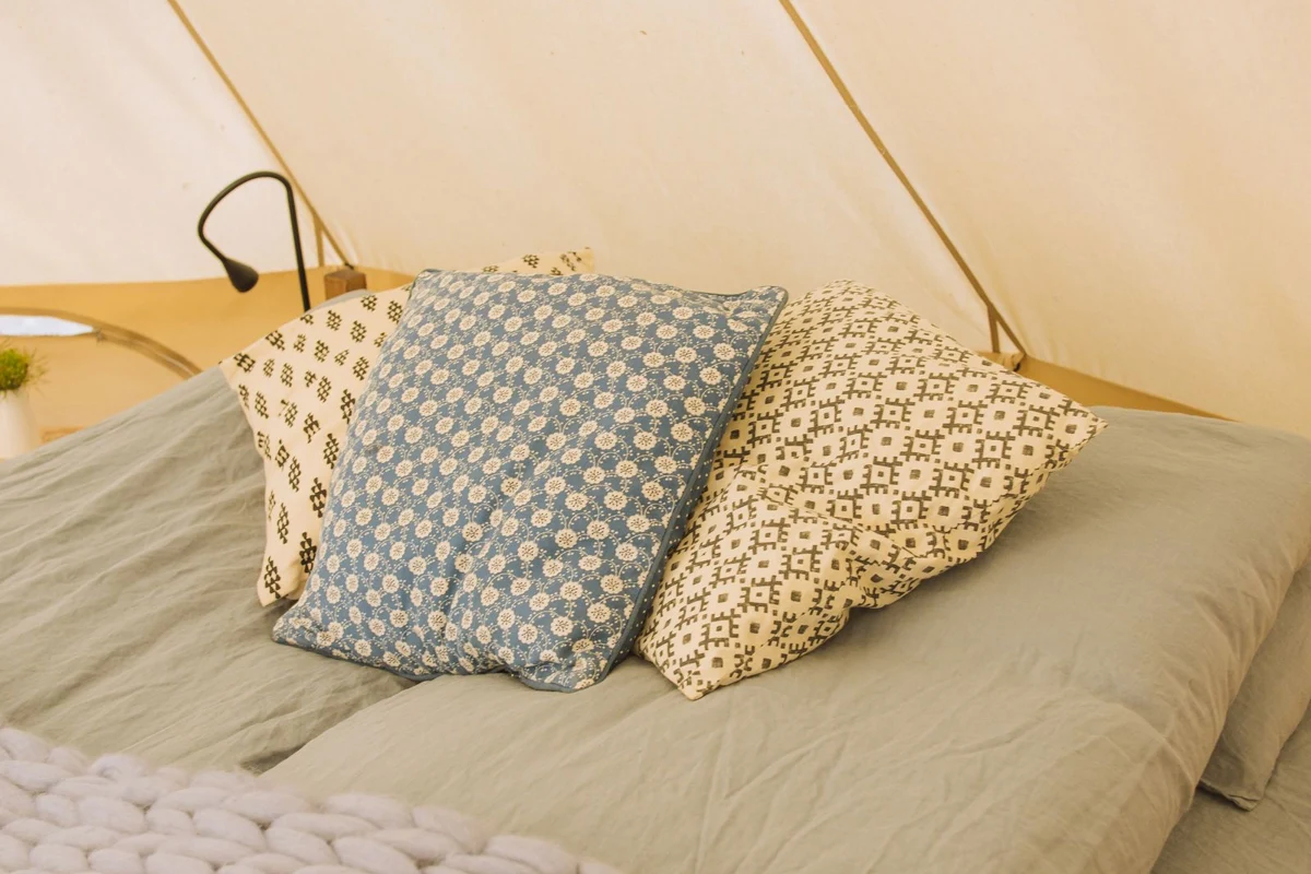 A light blanket and pillows on a bed