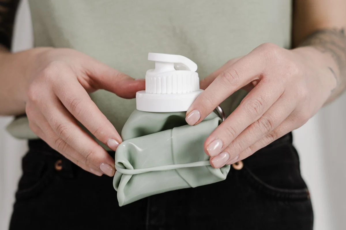 A hand holding a collapsible reusable bottle