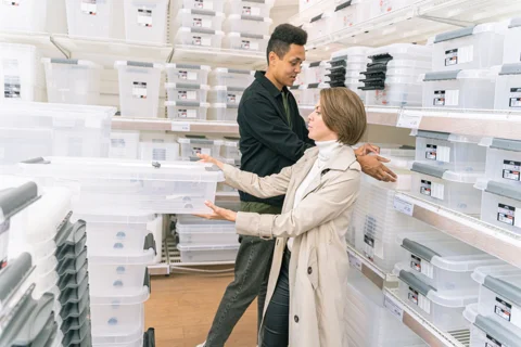 People comparing storage boxes in a shop