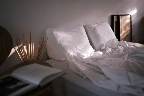 A bed dressed with linen and a duvet