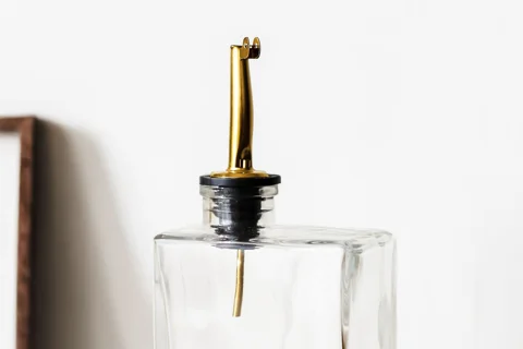 Glass oil bottle with a narrow metal pourer