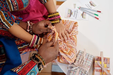 Hands tying cloth around a gift
