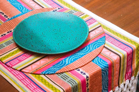 Plates arranged on a colourful table runner