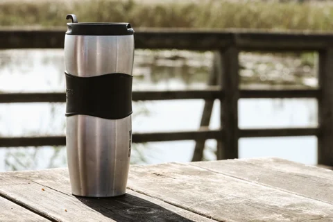 A metal travel mug with a lid